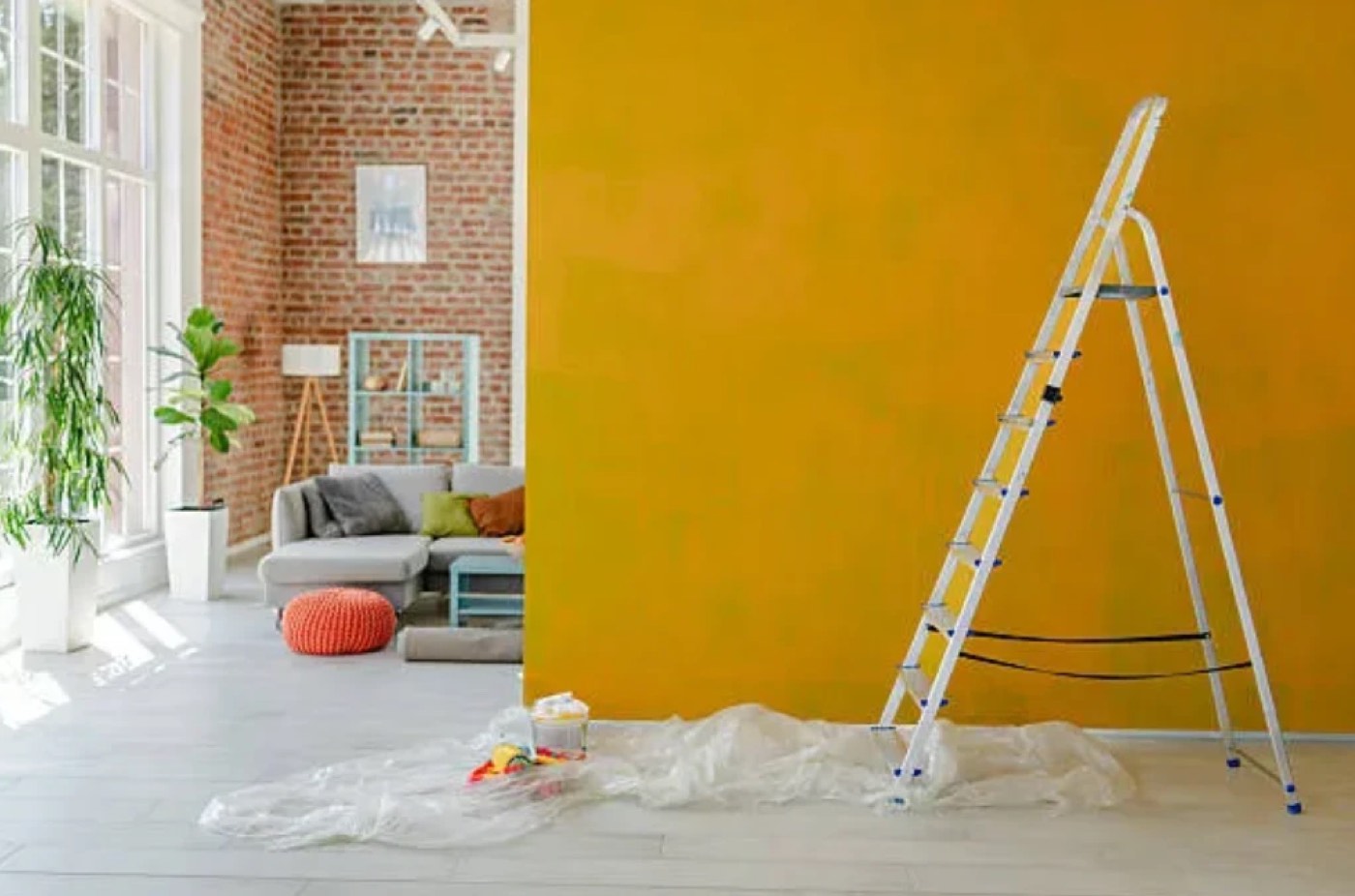 Mur fraîchement peint, plancher protégé par une bâche