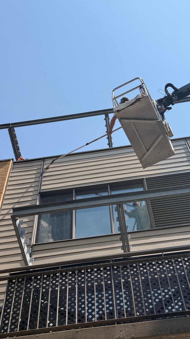 Peintre en nacelle sur un revêtement extérieur