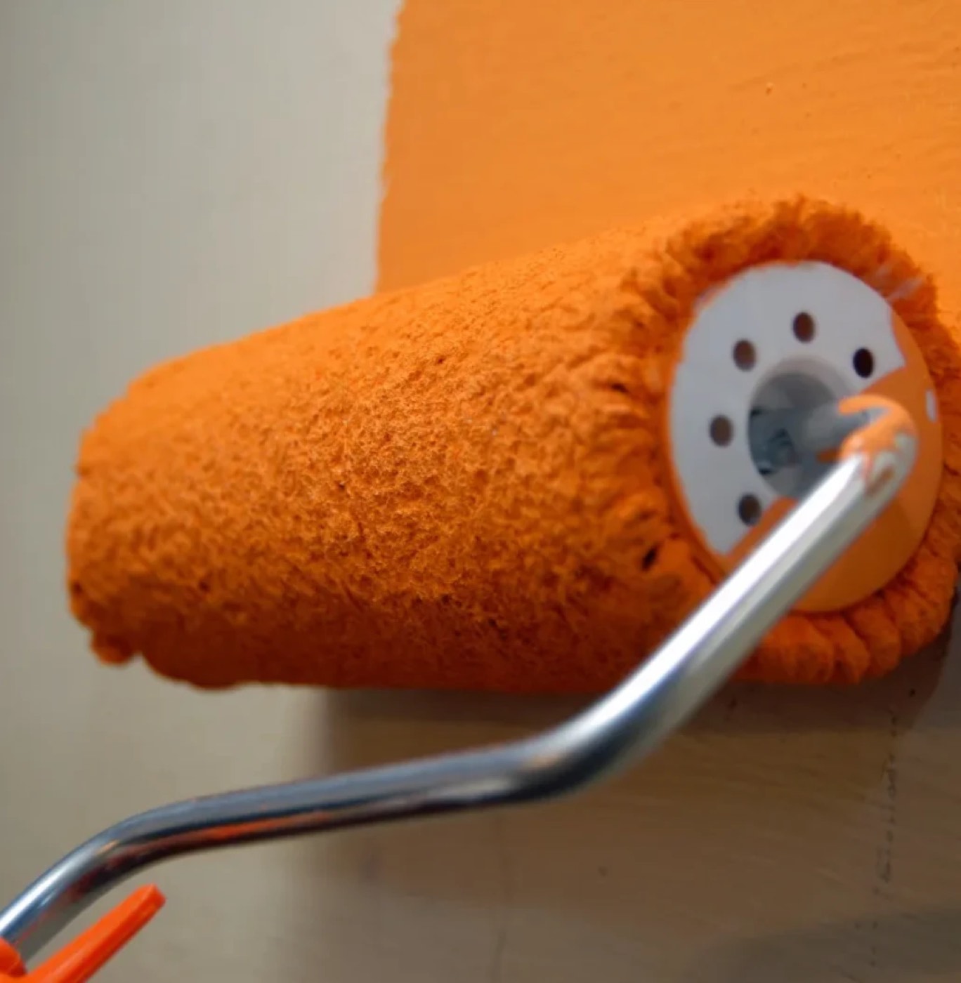 Rouleau chargé de peinture sur un mur